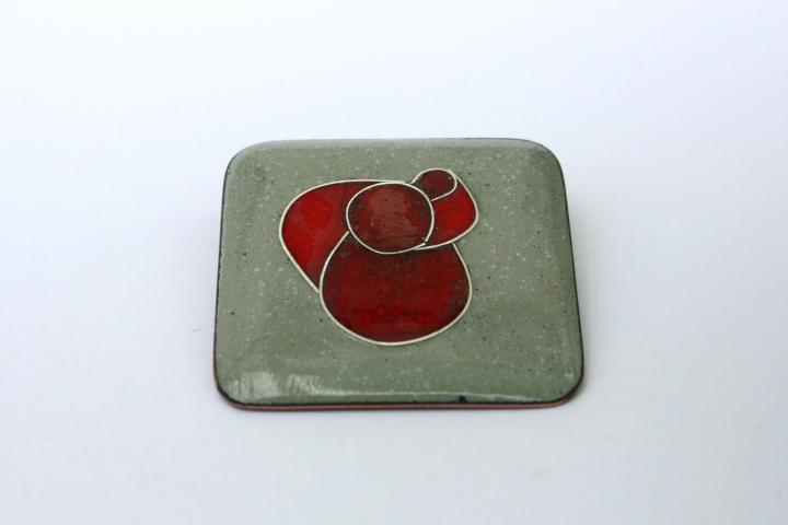 brooch with red circles on dove grey background